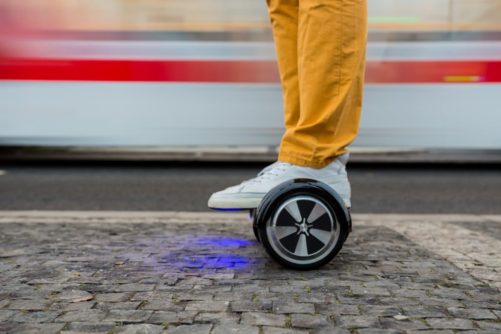 man using hoverboard against the background of the tram